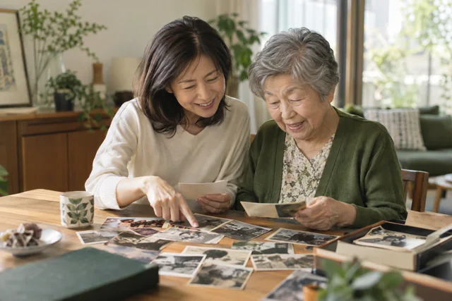 家族の写真を見返しながら話す親子のイメージ